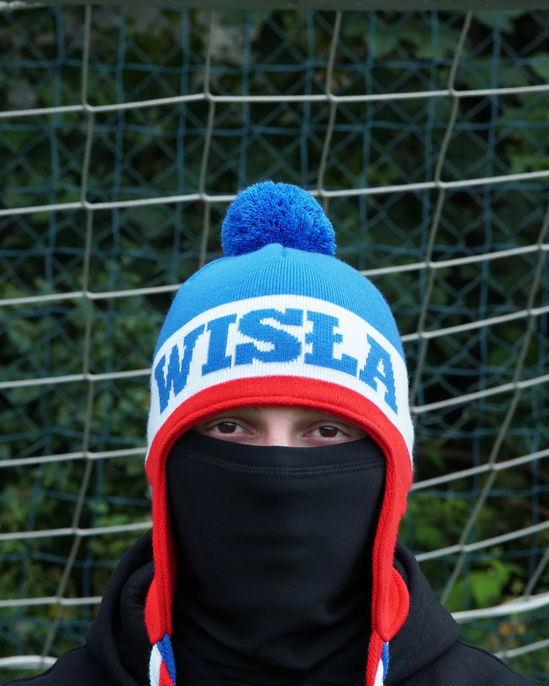 Niebieska uszatka z pomponem i napisem Wisła, na modelu w kominie