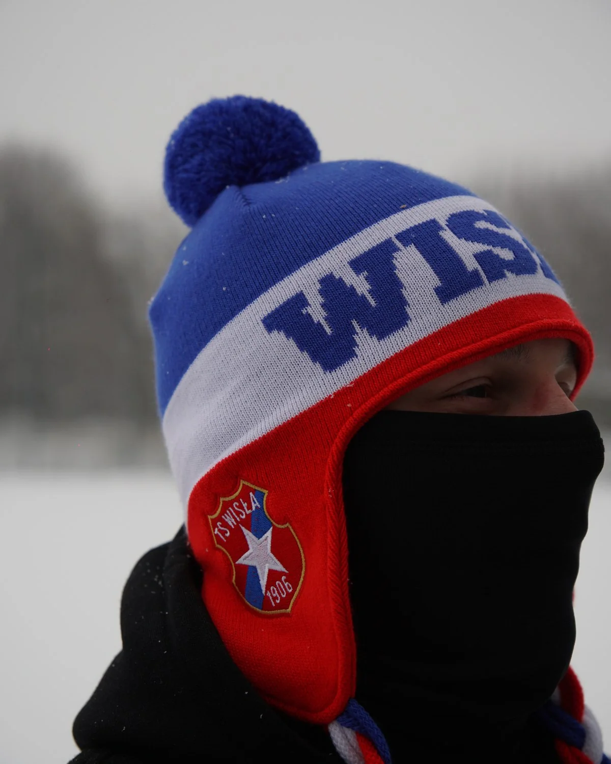 Biało-niebieska uszatka z pomponem i herbem TS Wisła