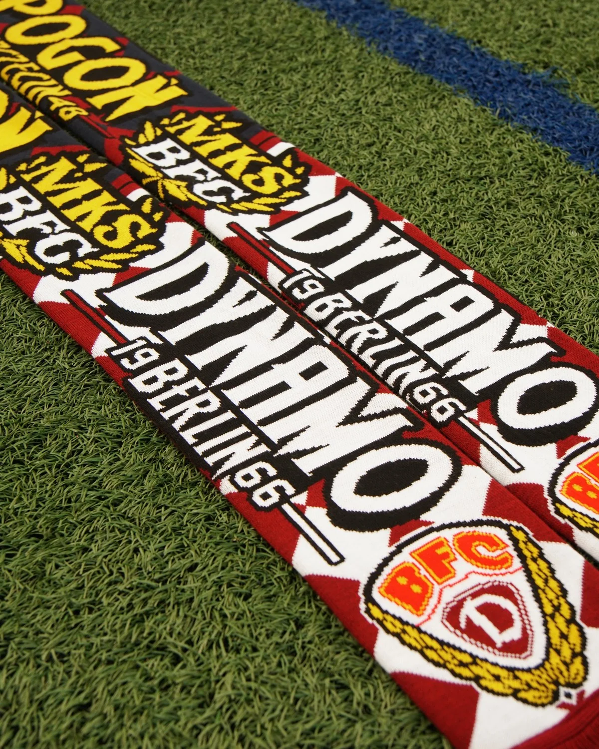 Czerwono-biały szalik dziany Dynamo Berlin z herbem BFC, ułożony ukośnie