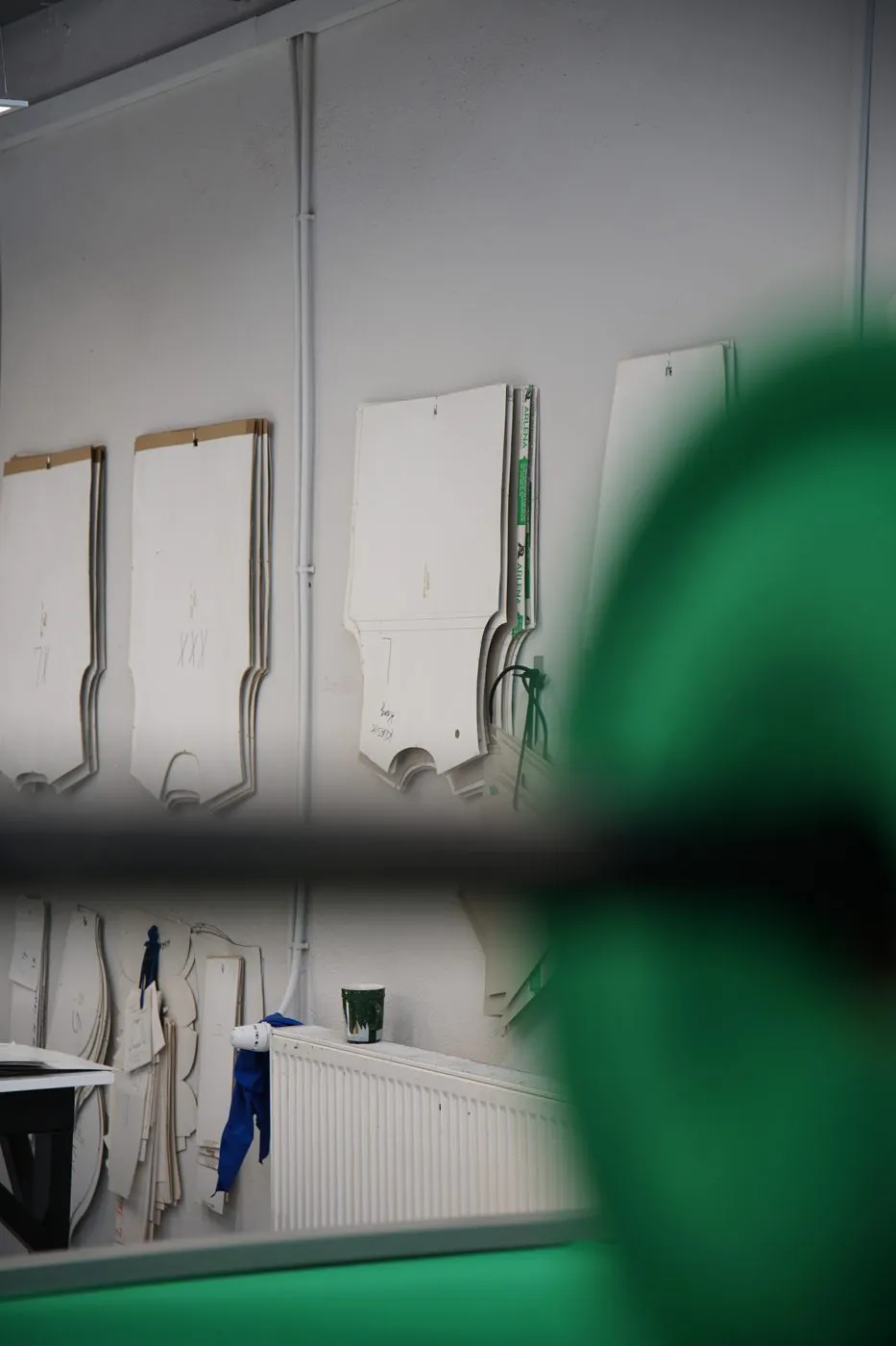 Szablony wykrojów zawieszone na ścianie pracowni