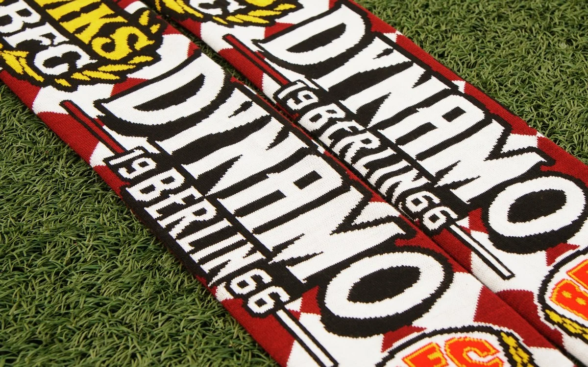 Czerwono-biały szalik dziany Dynamo Berlin z herbem BFC, ułożony ukośnie