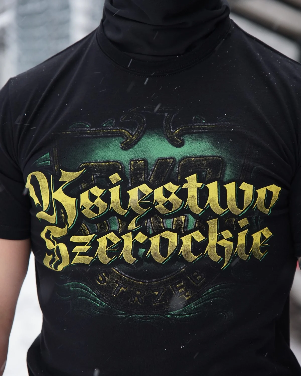 Czarny T-shirt z żółto-zielonym napisem Księstwo Szerockie na modelu