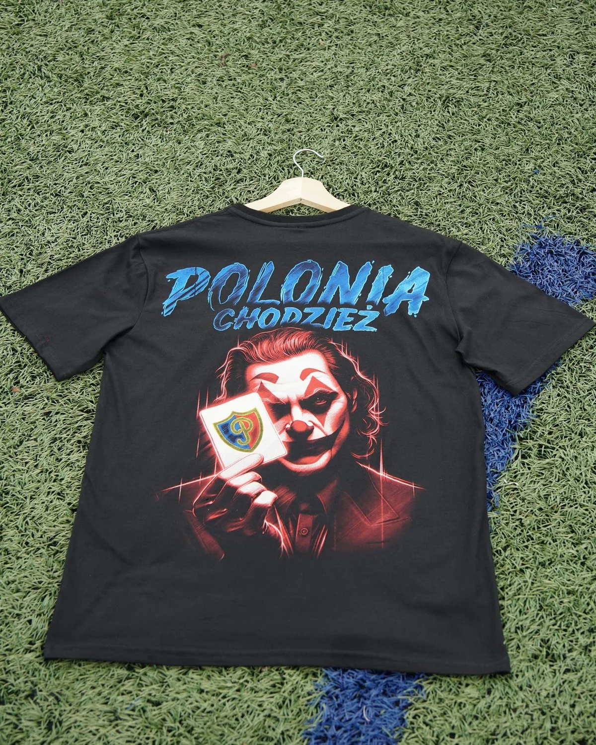 Czarny T-shirt z niebieskim napisem Polonia Chodzież i postacią Jokera trzymającego herb klubu