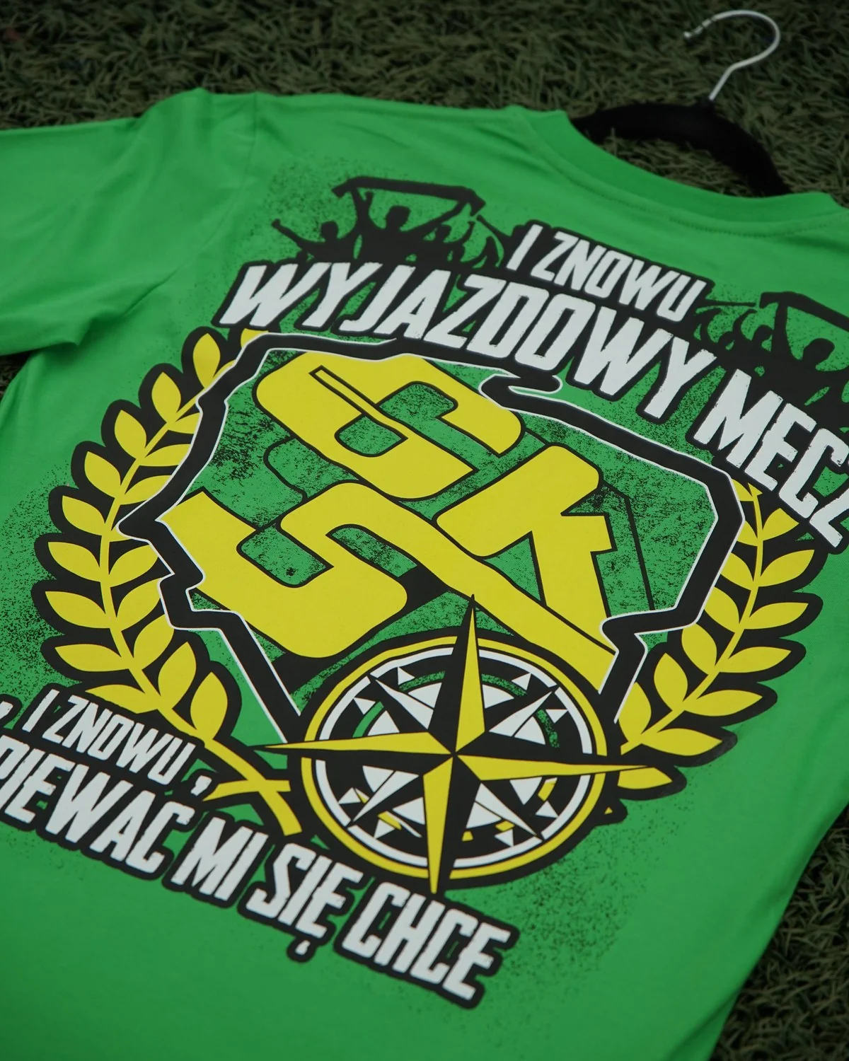 Zielony T-shirt Górnika Łęczna z dużym żółto-czarnym nadrukiem „I znowu wyjazdowy mecz” w wieńcu laurowym